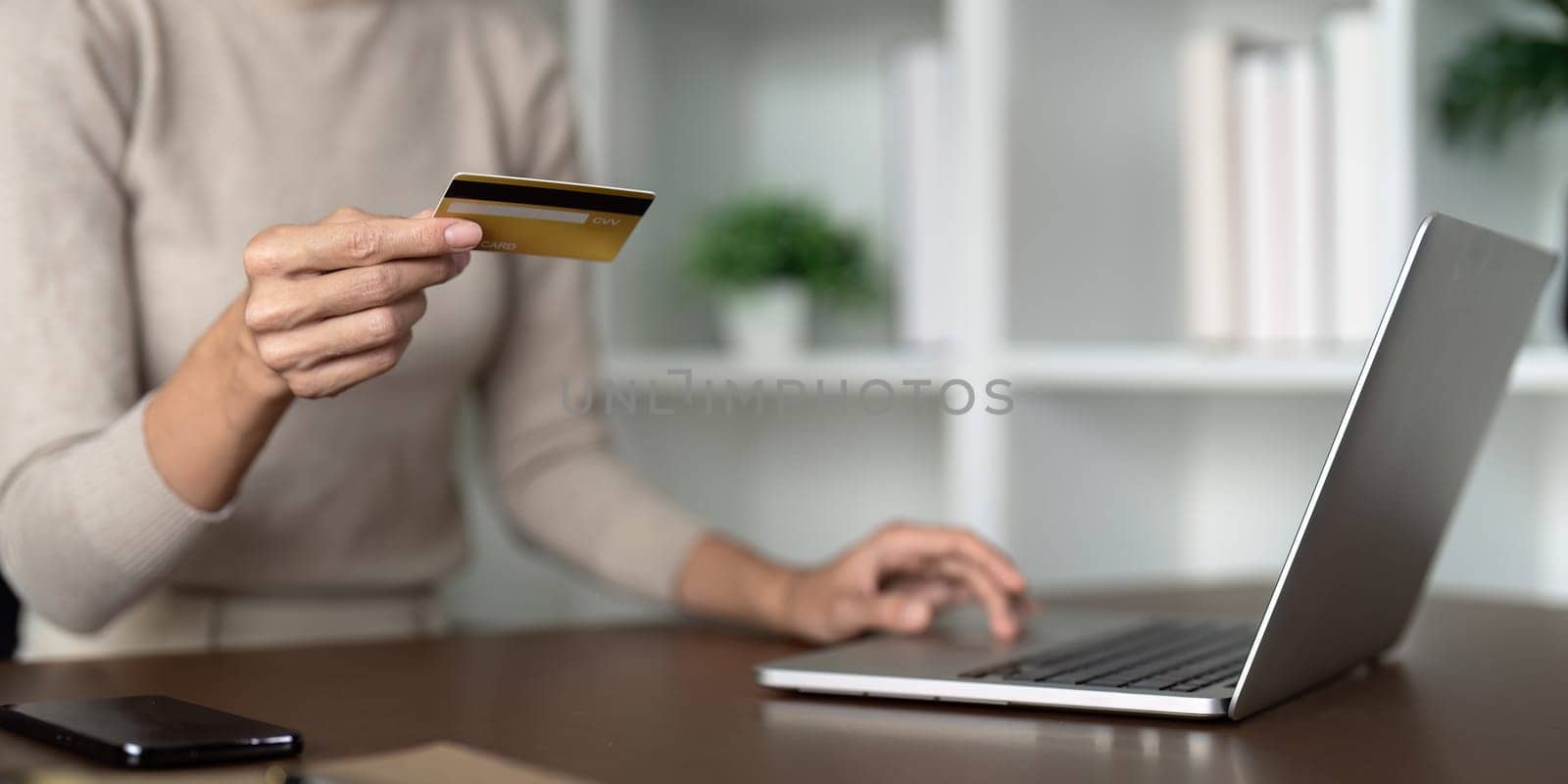 Woman use credit card on laptop and online shopping, payment and ecommerce at home, bank app and sale on store website with internet banking by nateemee
