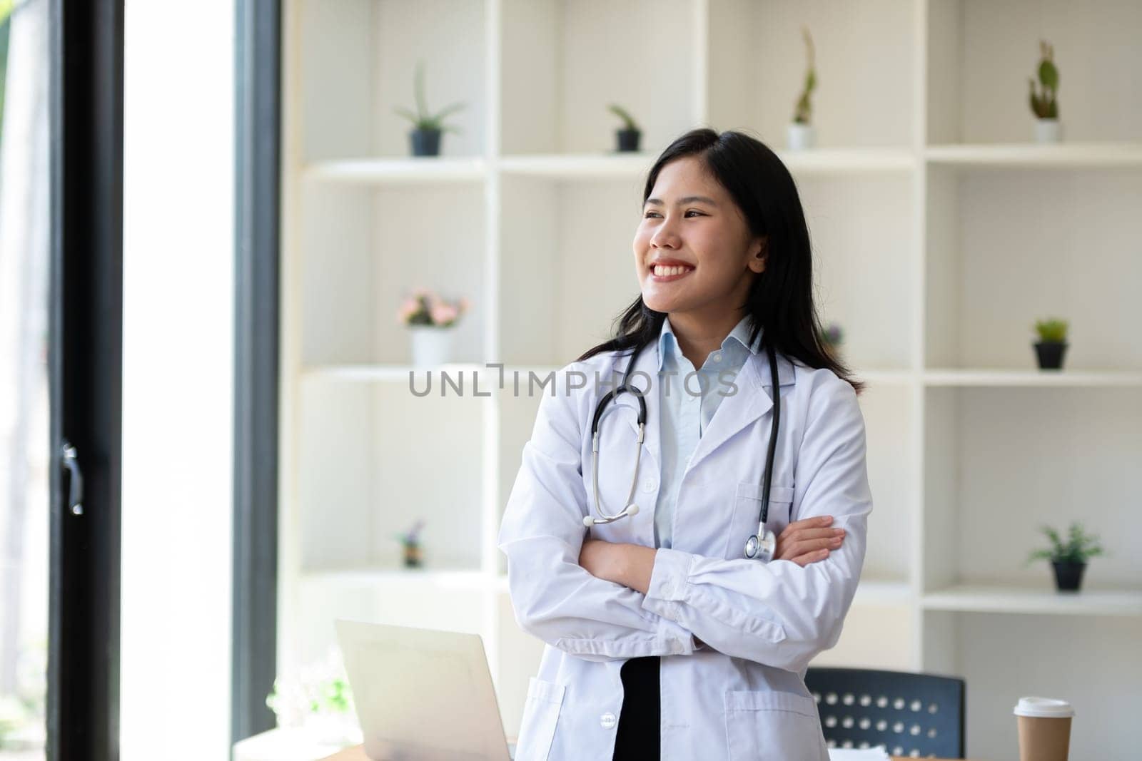 Portrait of confident young female doctor standing in clinic by wichayada