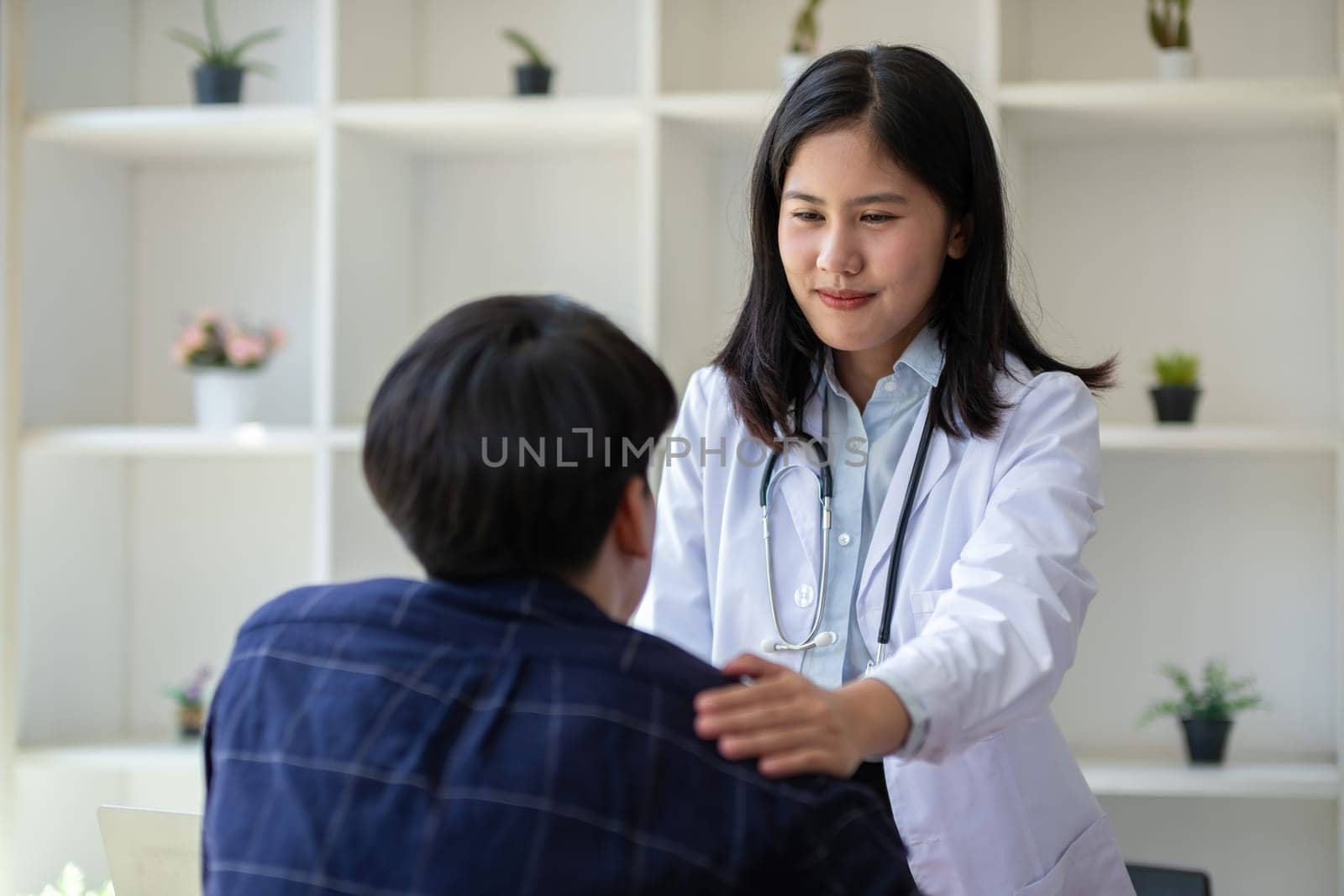 Female doctor gives advice to young patient who is stressed and has health and medical problems in clinic.