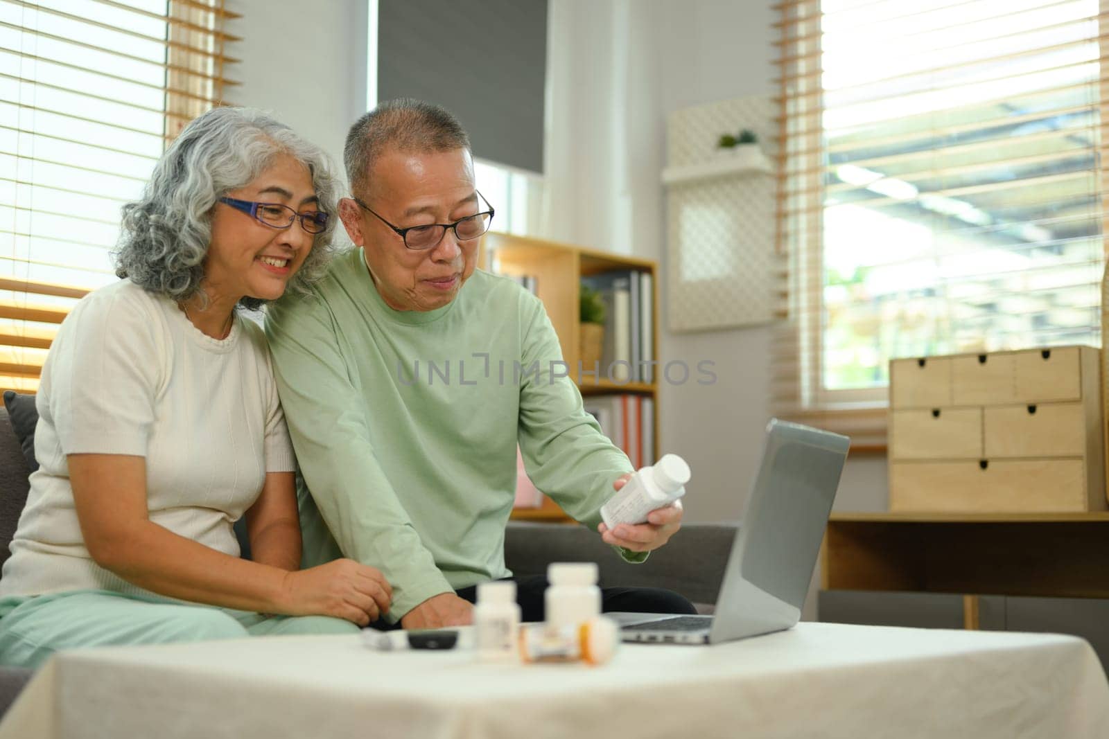 Smiling mature couple discussing prescription medications with doctor on video call. Telehealth concept by prathanchorruangsak