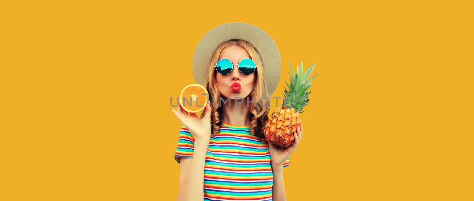 Summer portrait of happy young woman with pineapple, fresh tropical fruits on yellow background by Rohappy