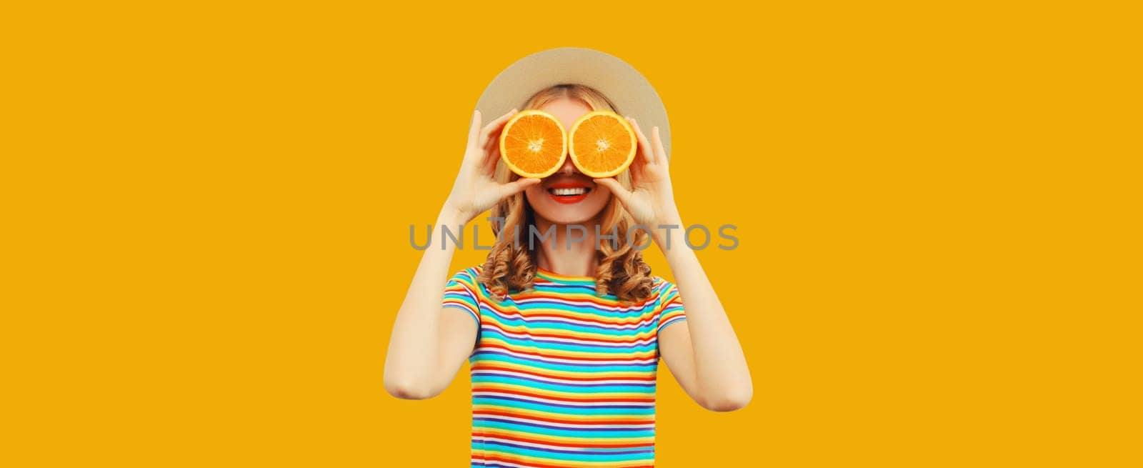 Summer vacation portrait of happy young woman with fresh fruits, slice orange on yellow background by Rohappy