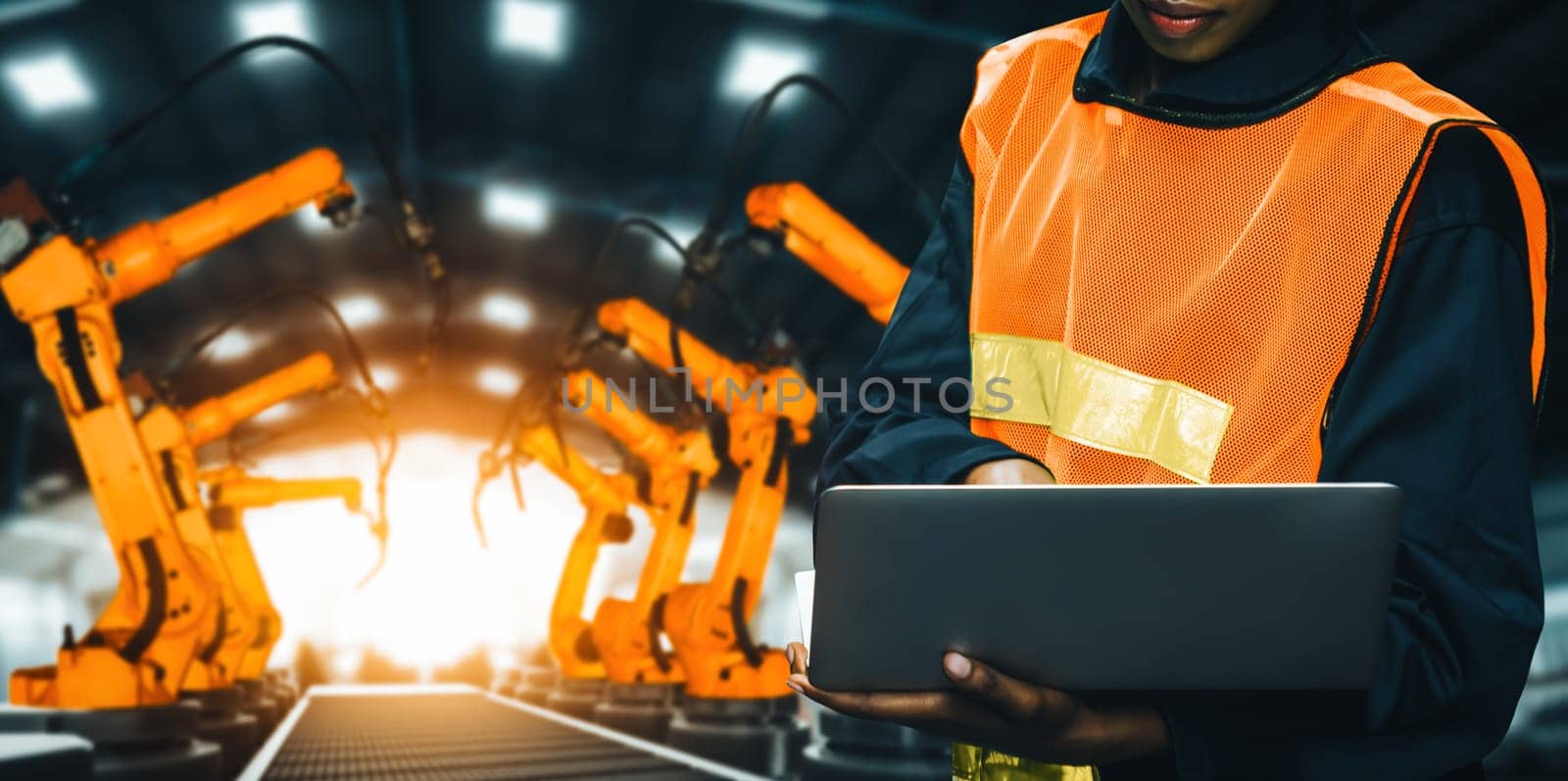 MLP Engineer use advanced robotic software to control industry robot arm in factory. Automation manufacturing process controlled by specialist using IOT software connected to internet network.