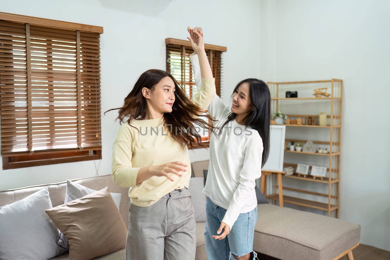 gay couple dancing together in healthy relationship love connection at home. Lgbtq couple concept by itchaznong
