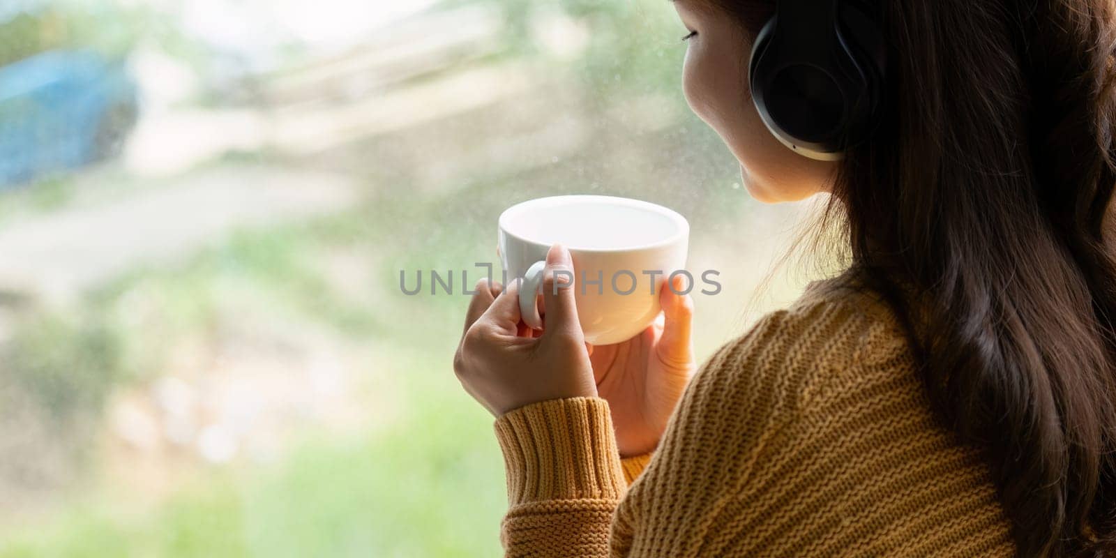 Beautiful young asian woman enjoy drinking coffee and listening to music with headphone at desk home, happiness and relaxation concepts.