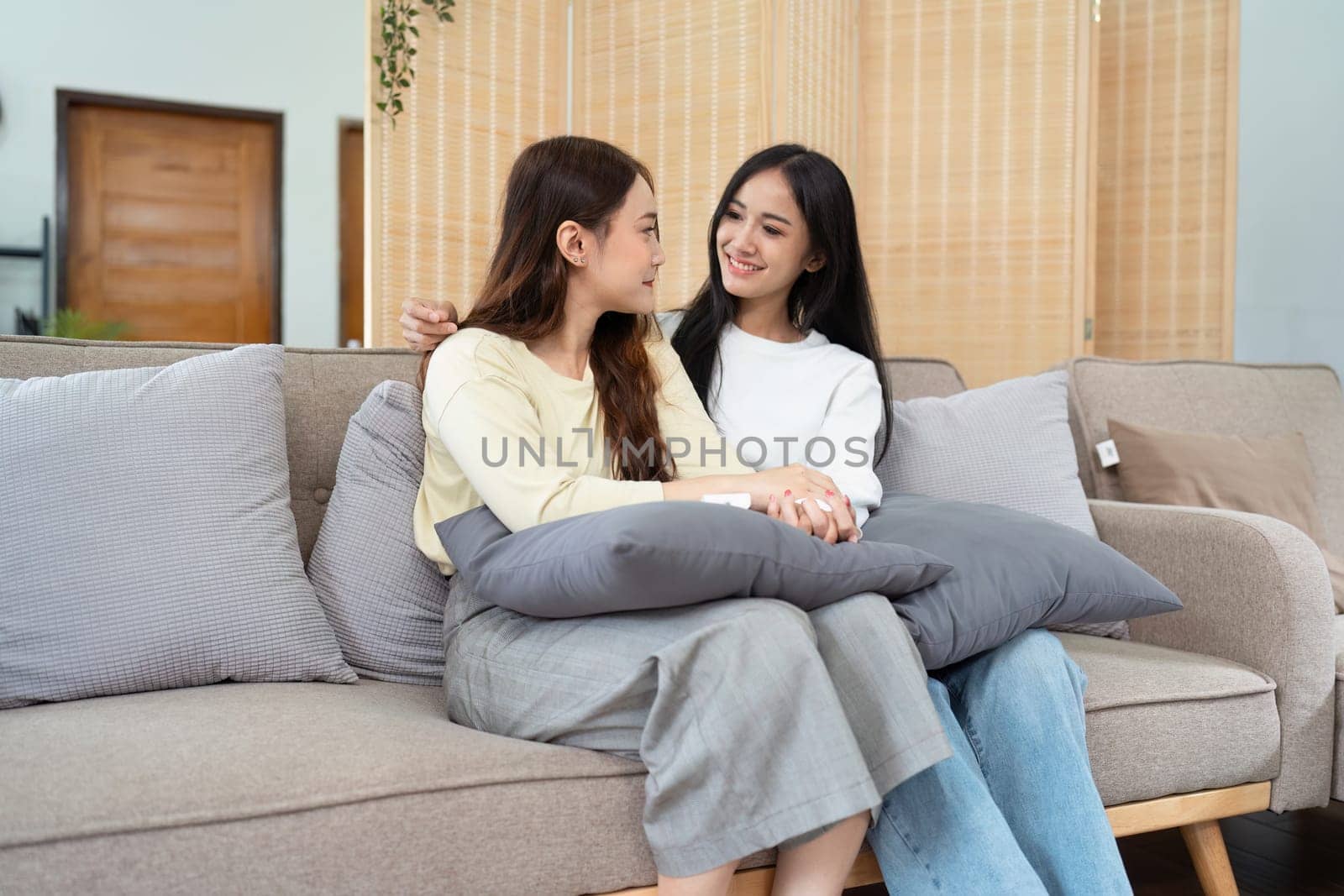 gay couple hug on sofa to relax together in healthy relationship love connection. Lgbtq couple concept.
