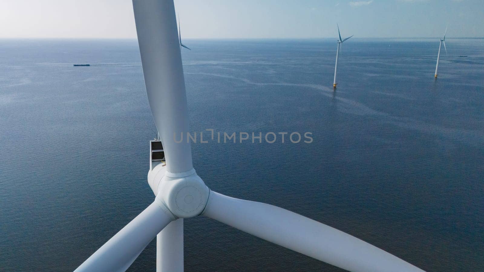 A wind farm with tall windmill turbines standing majestic in the ocean waters, harnessing the energy of the wind to generate power by fokkebok