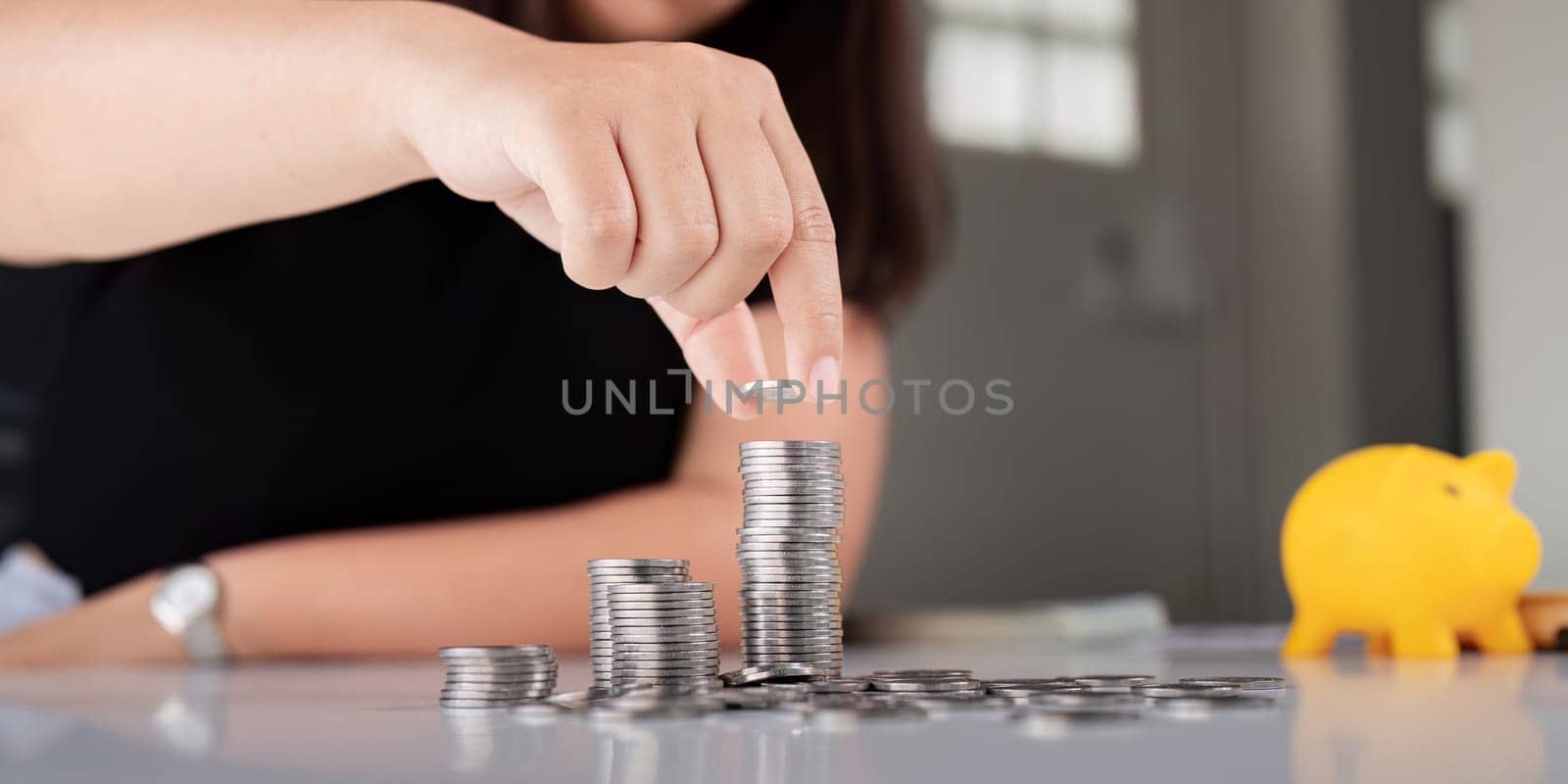 Young Asian woman making stack of coin. invest save finance concept, saving money, investment by nateemee