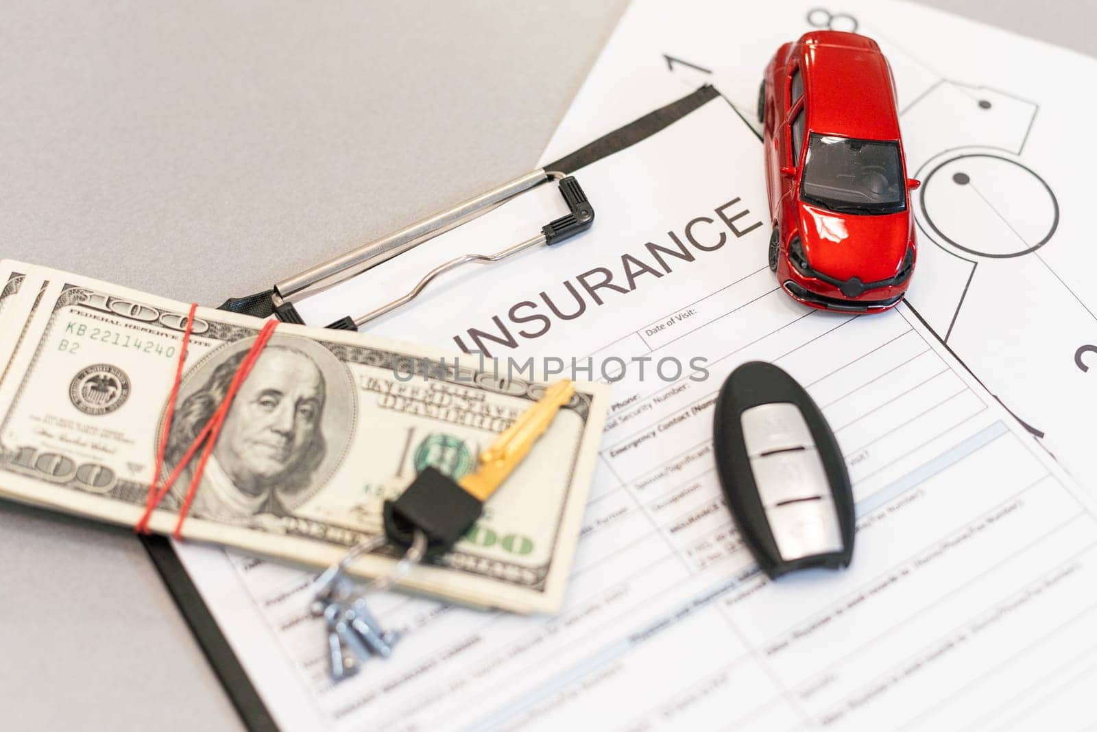 Top view of car insurance claim form with car key and car toy on desk. High quality photo