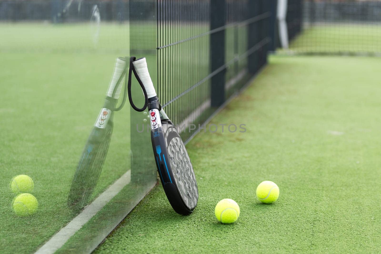 Paddle tennis racket, ball and net on the grass . High quality photo