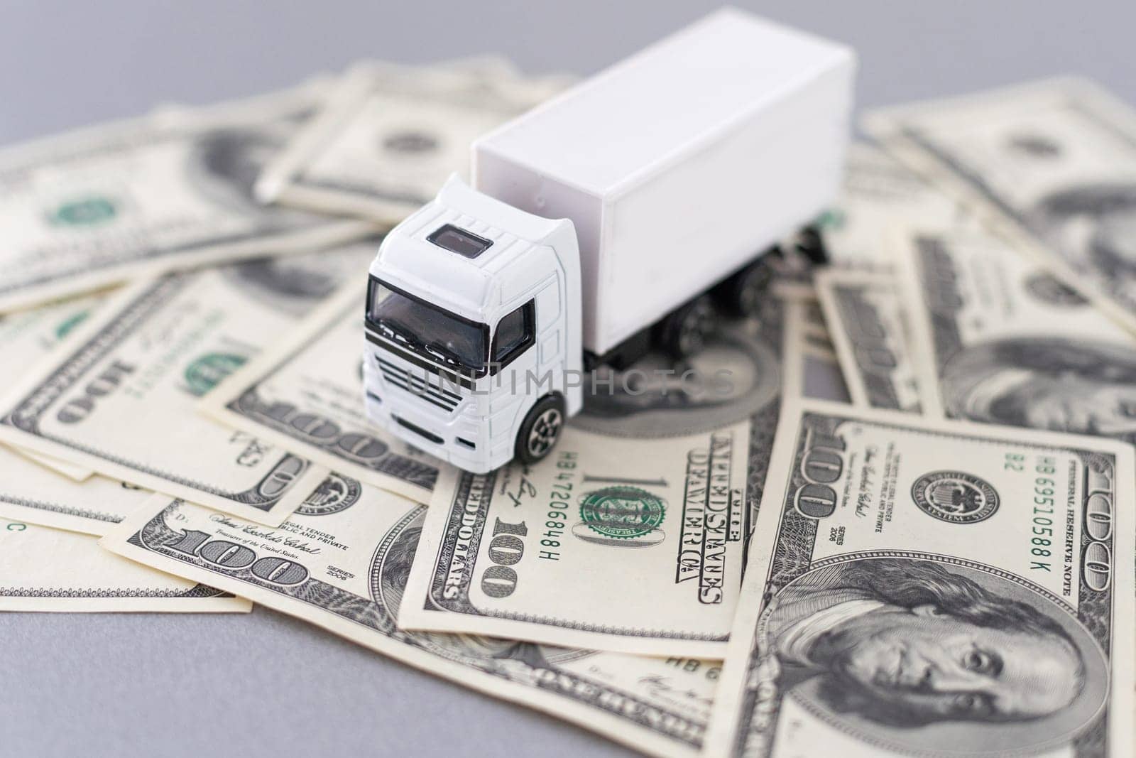White toy truck lie on dollars, space for text. High quality photo