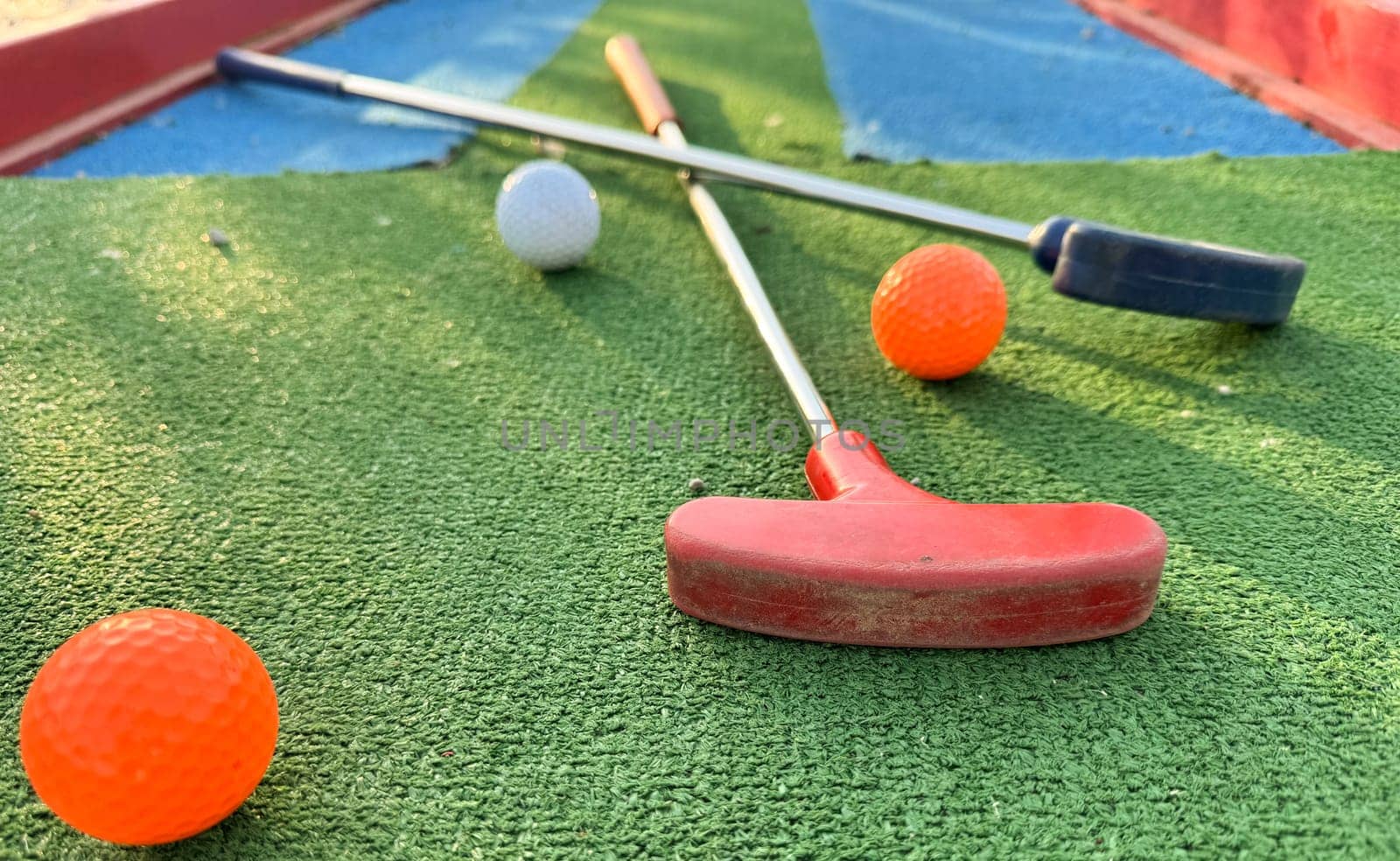 colorful golf putters with golf balls on synthetic grass. High quality photo