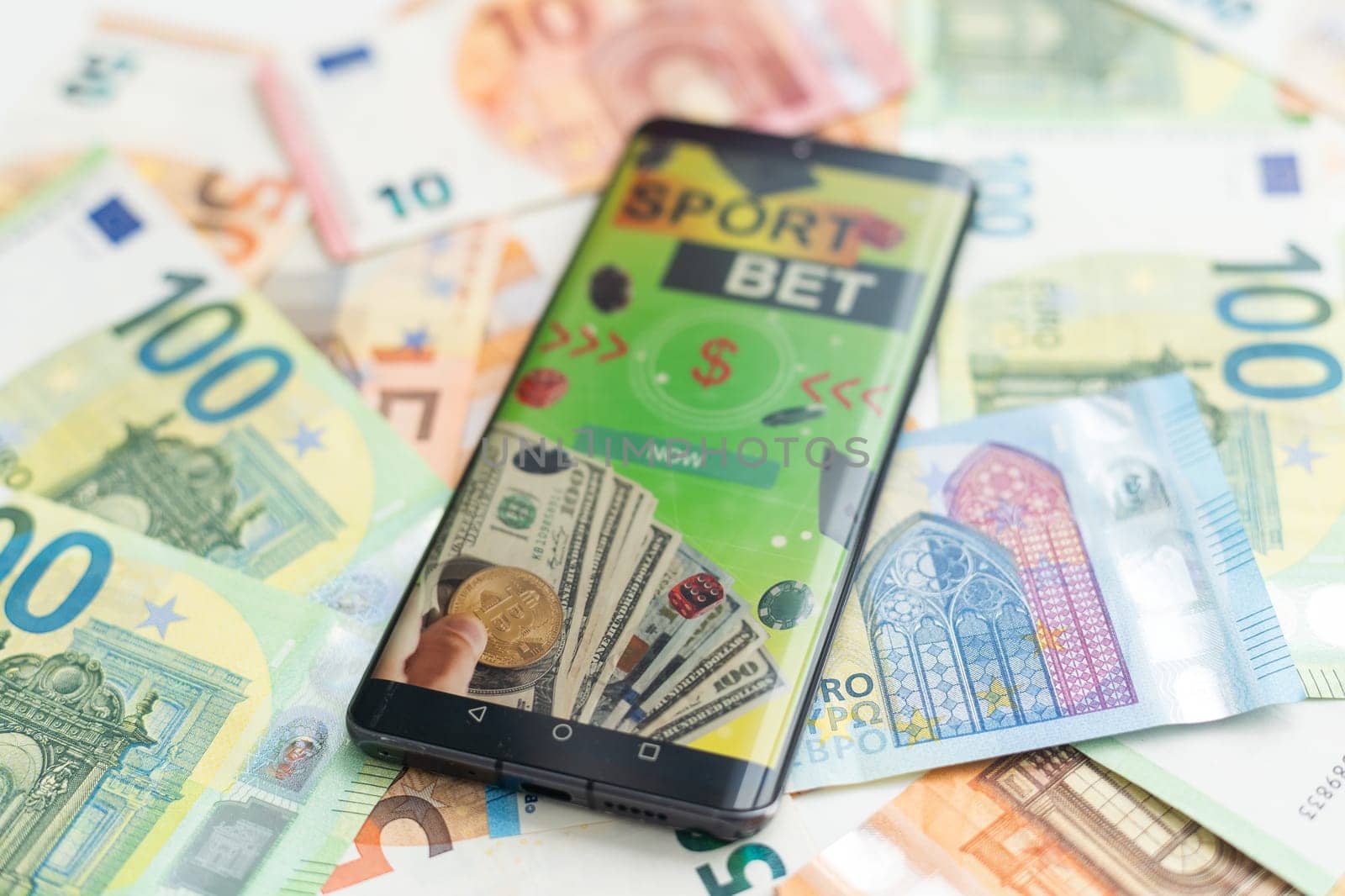 Sports betting website in a mobile phone screen, money. High quality photo