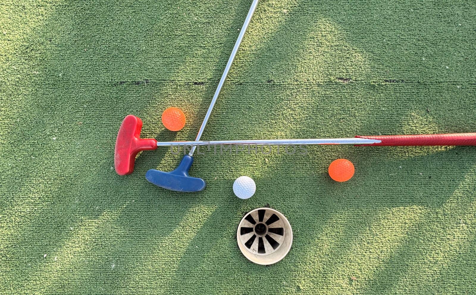 Golf ball and golf club on green in the evening golf course with sunshine . High quality photo