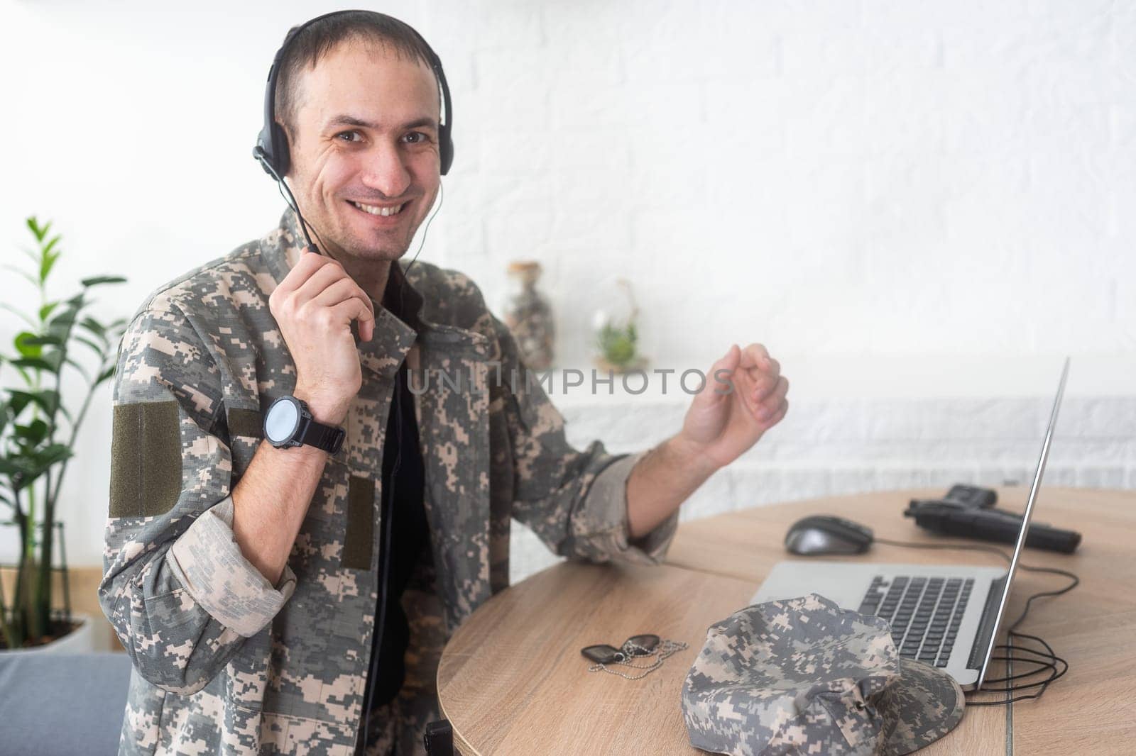 Young hispanic man army soldier using laptop sitting on table at home. High quality photo