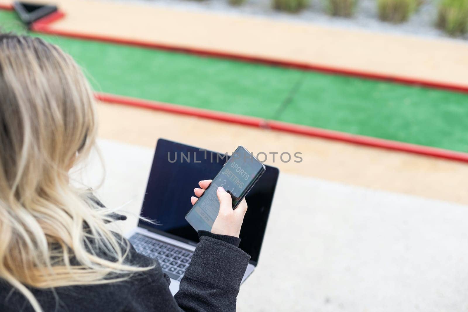 woman on golf course with smartphone with sports betting app. High quality photo