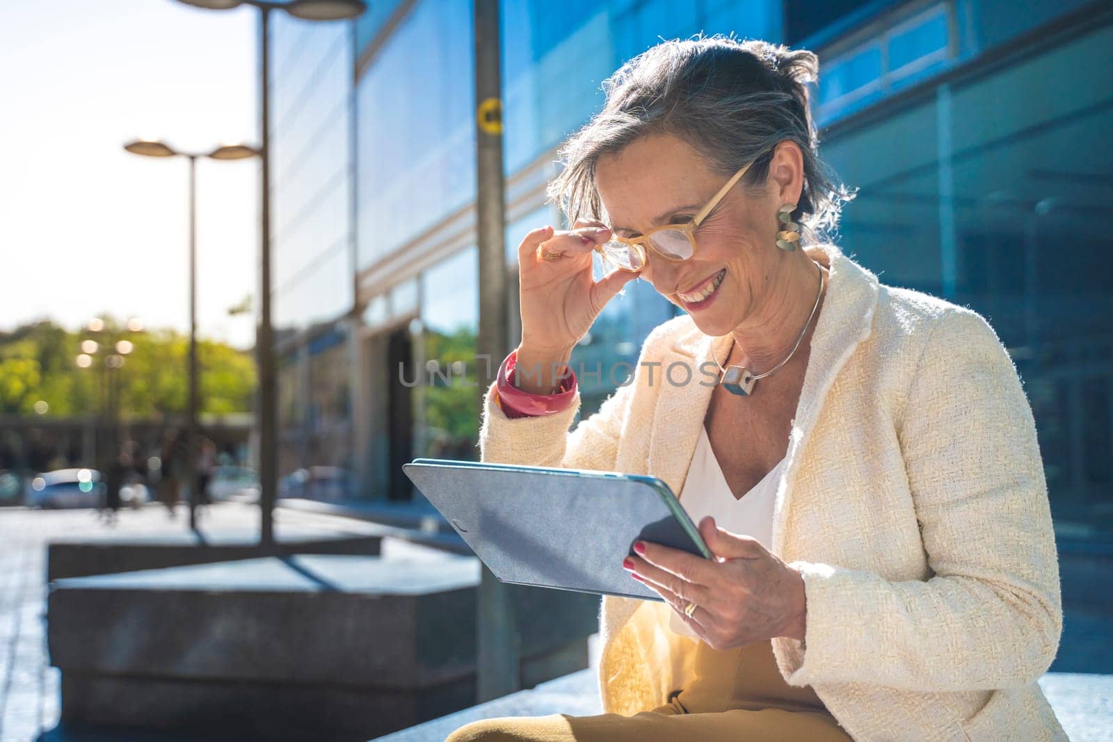 Senior business woman with technology happy working with a tablet in a modern city. High quality photo