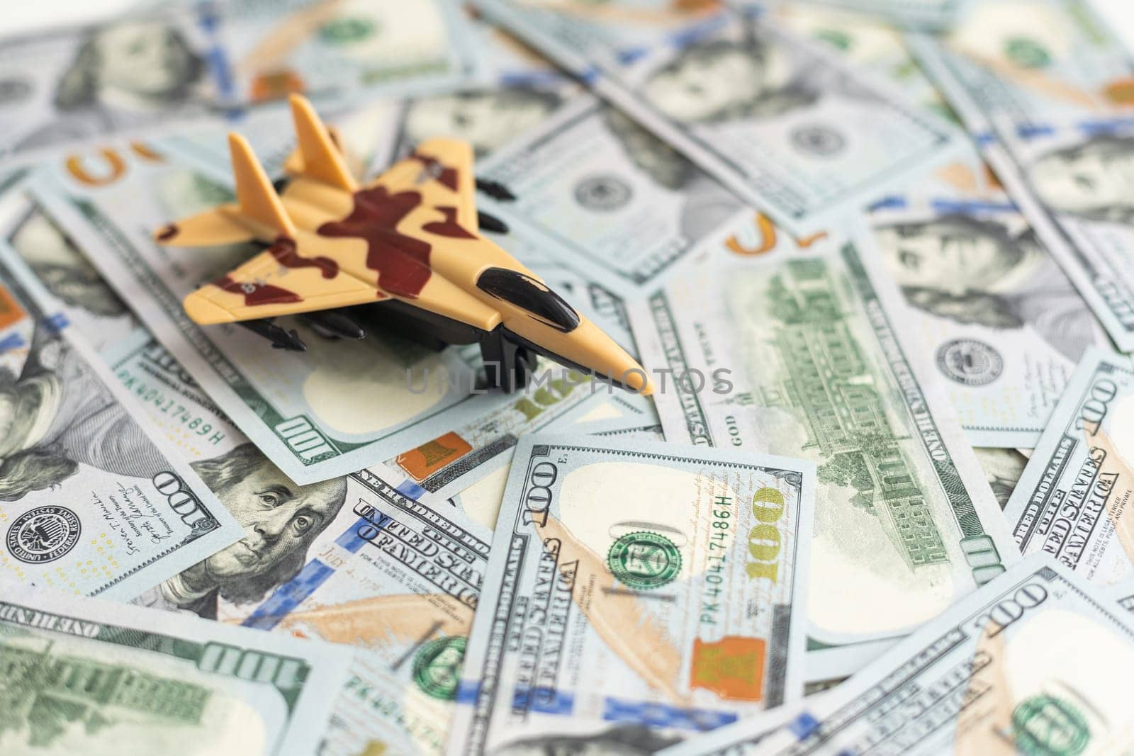 Background of one hundred dollar bills with model fighter airplane. High quality photo