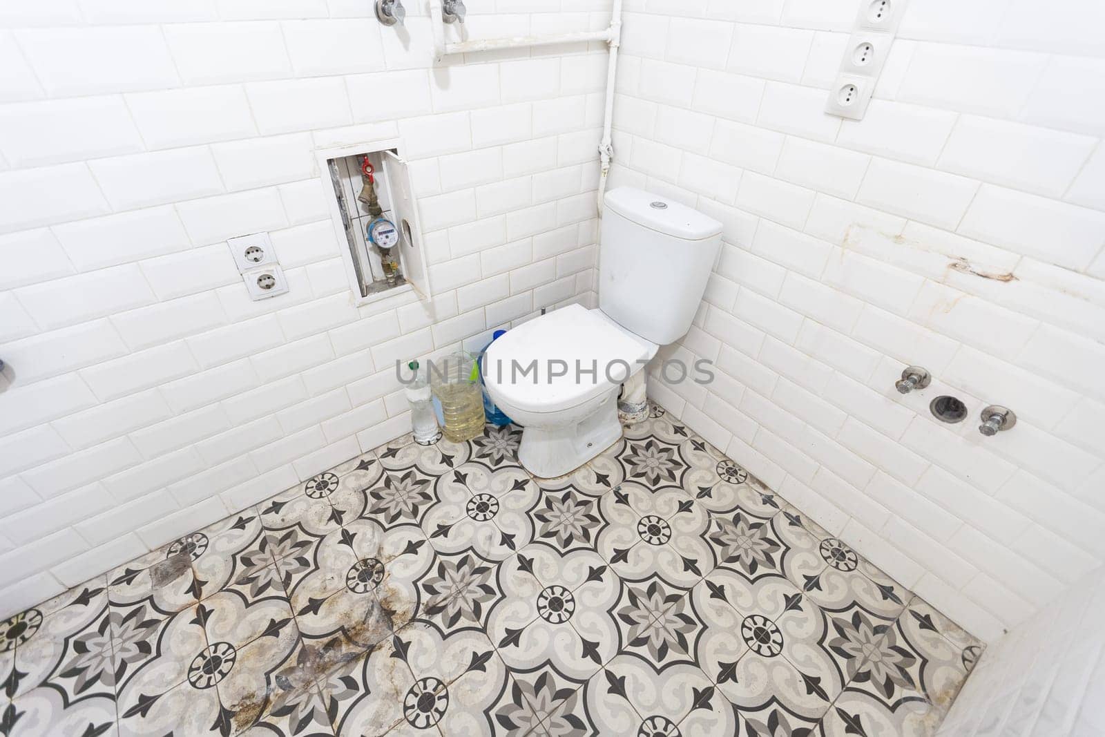 Interior of narrow restroom with wall hung toilet with white walls and checkered floor. High quality photo