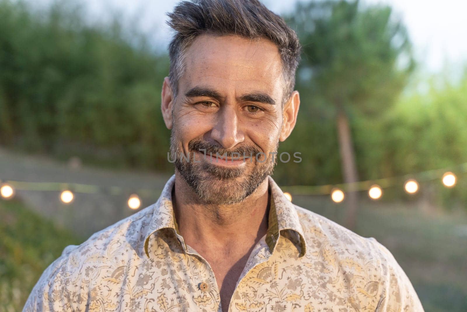 Good looking man portrait posing smiling in nature background in summer night. by PaulCarr