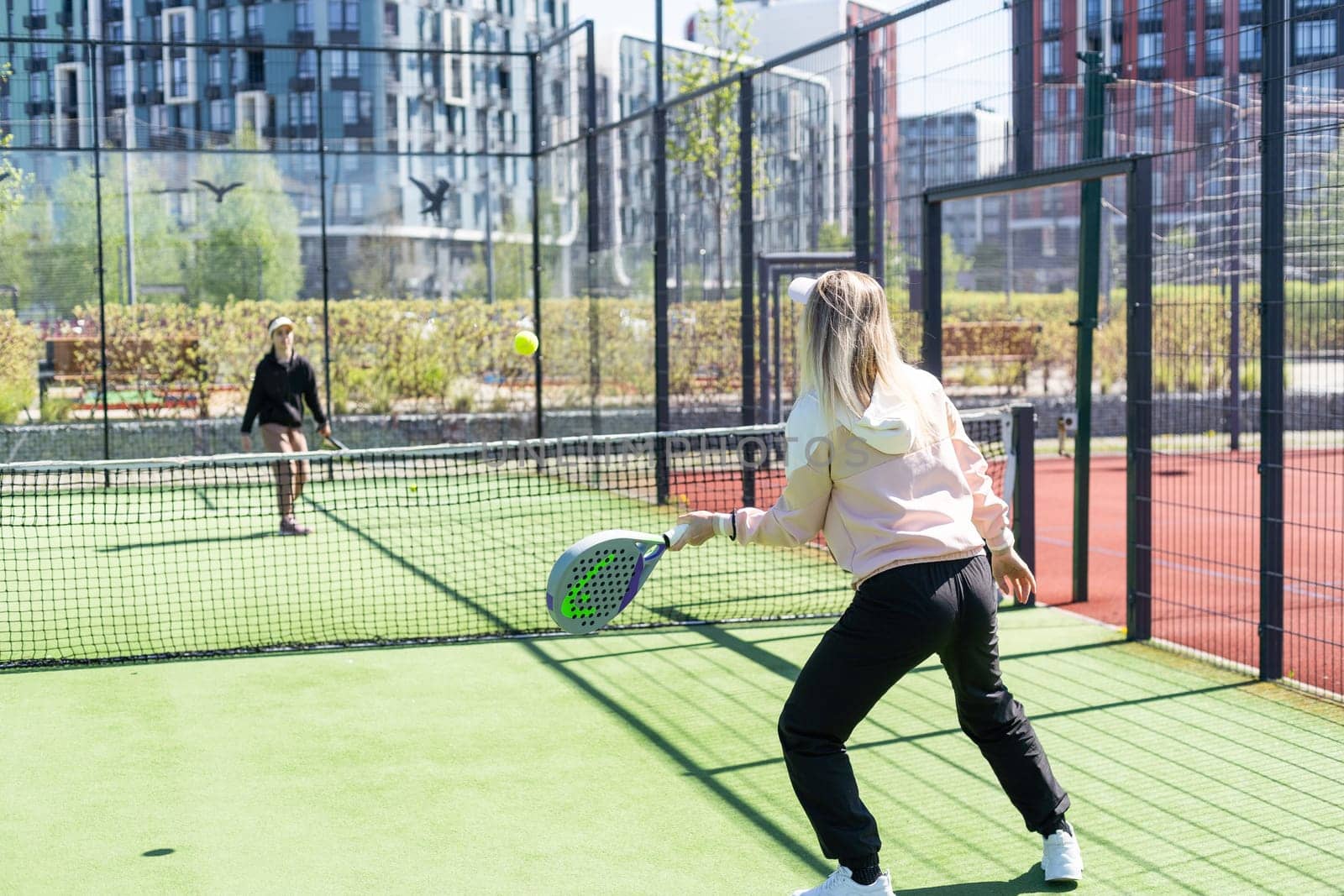 mother and daughter playing padel outdoor by Andelov13