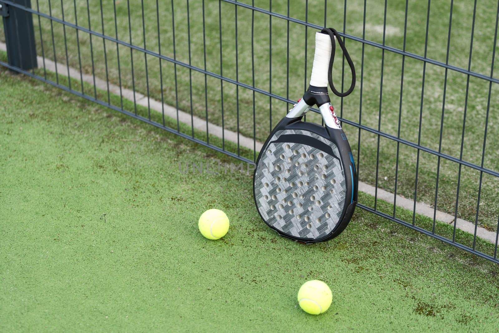 paddle tennis racket and balls on court . High quality photo