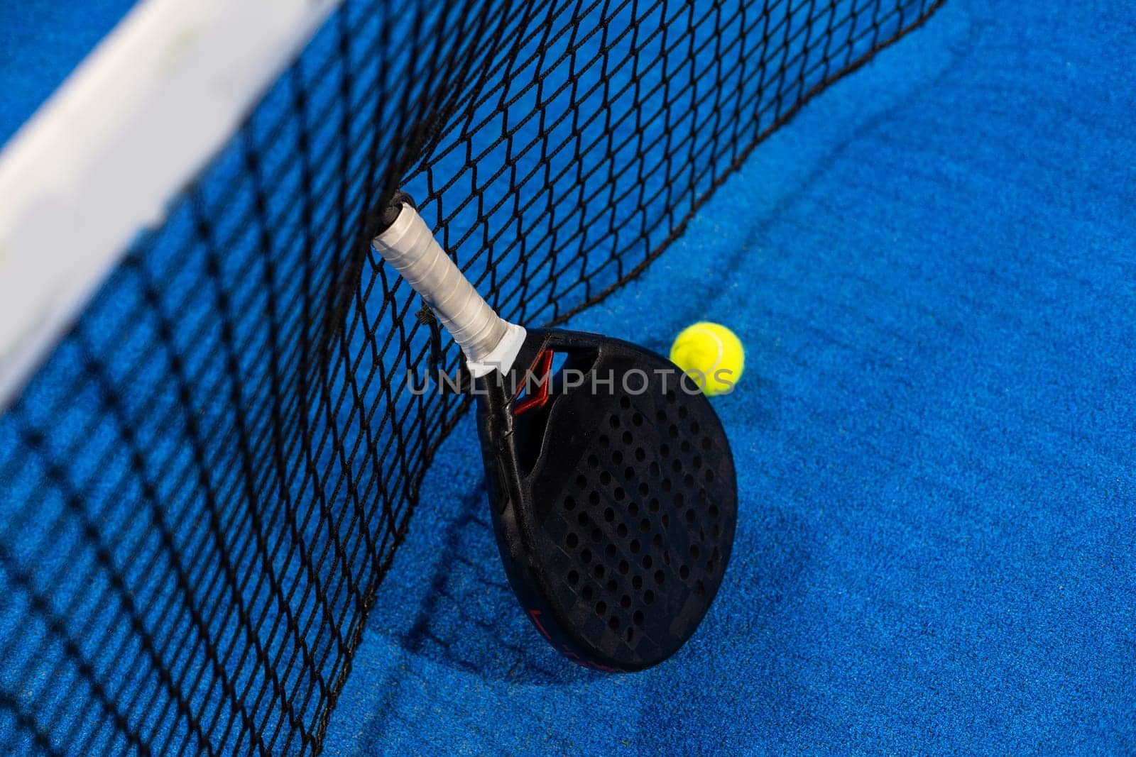 professional paddle tennis racket with natural lighting on blue background. Horizontal sport theme poster, greeting cards, headers, website and app. High quality photo