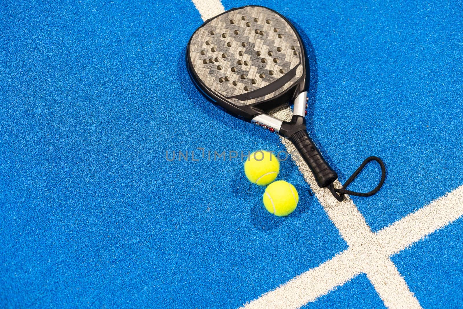 paddle tennis racket and balls on the blue paddle court. High quality photo