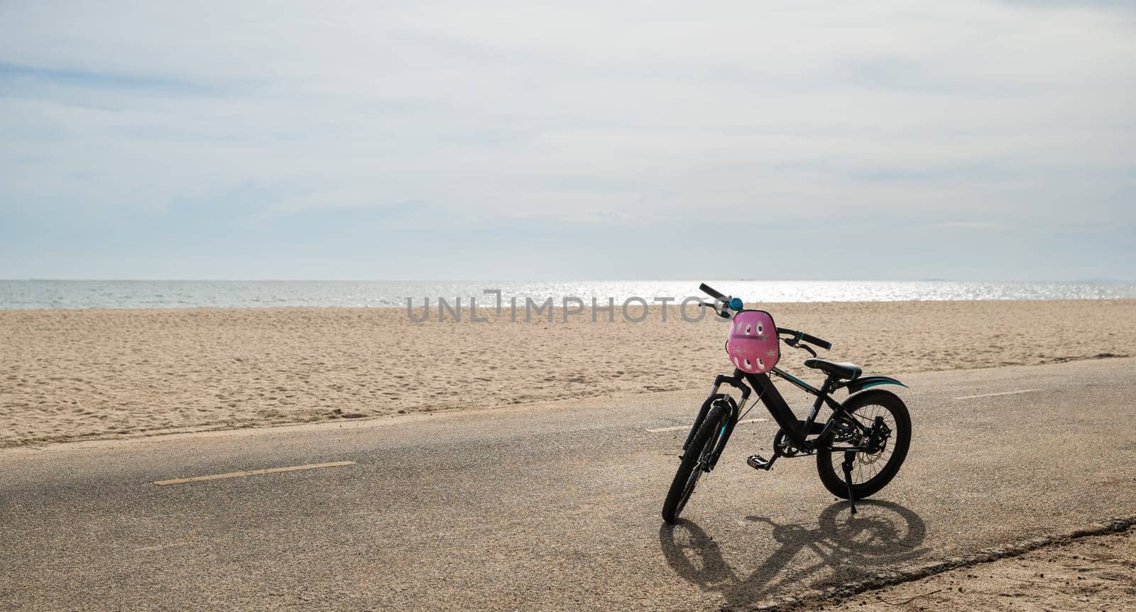Seascape serenity, A child bicycle rests peacefully on the sandy beach creating a perfect image of leisurely tourism day in North California sun during the summer season. bike in summertime vacations