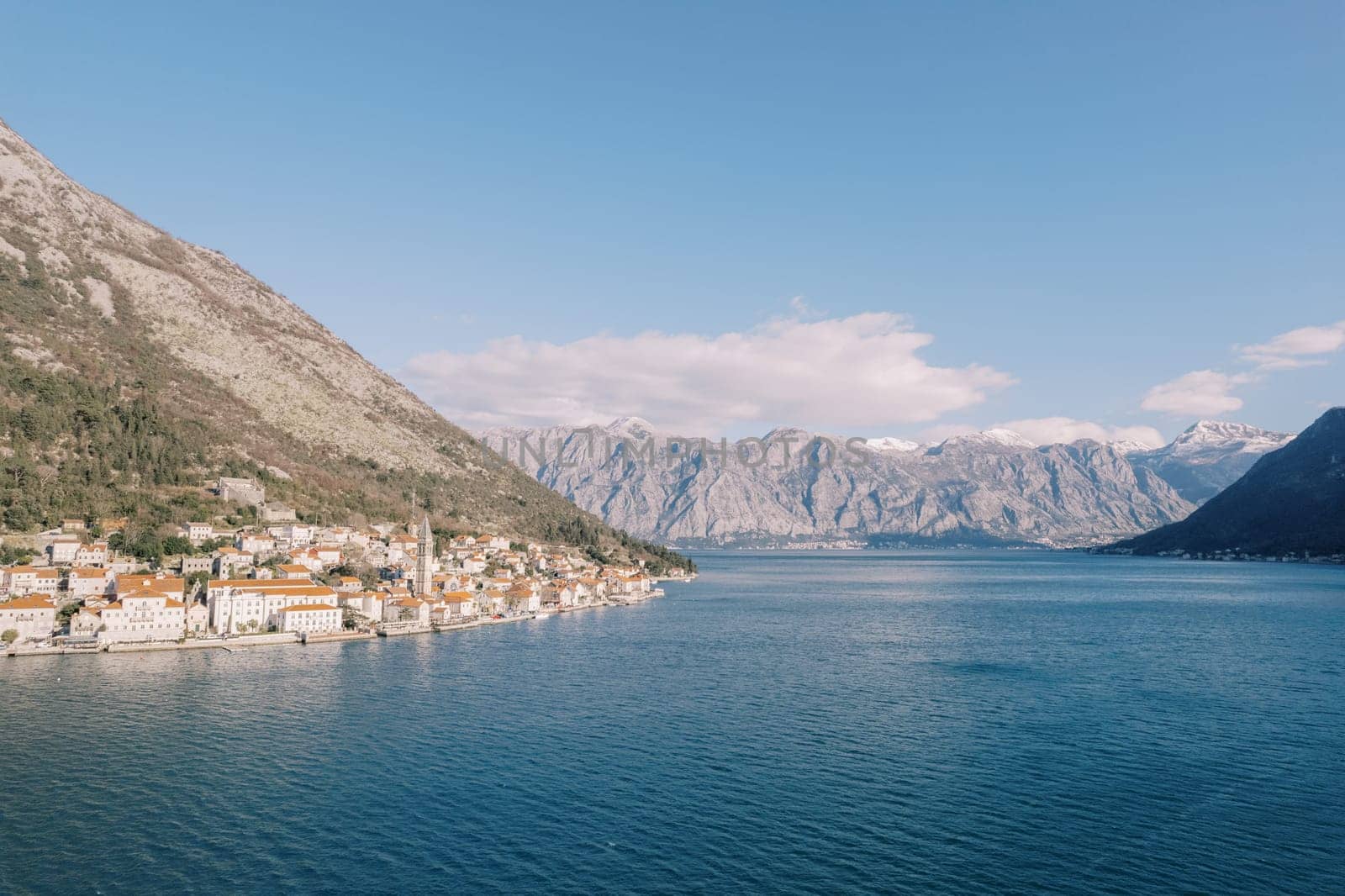 View from the sea on the coast of the ancient town of Perast at the foot of the mountains. Montenegro. Drone. High quality photo
