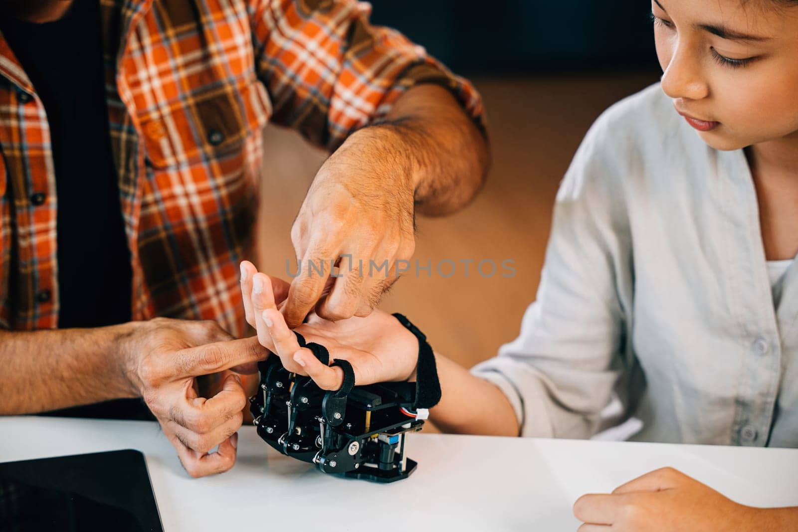 Teacher helps student build robotic arm in classroom design and technology lesson. Fostering innovation discovery and coding skills for science education. Robot hand. Innovation and technology concept by Sorapop