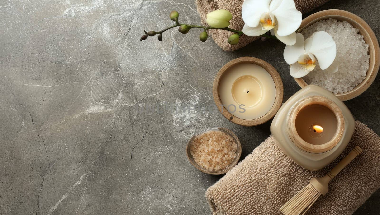 Serene spa setting with candles and orchid on textured grey background