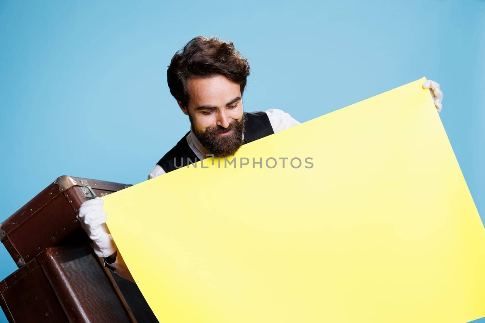 Hotel concierge holds empty yellow sign by DCStudio