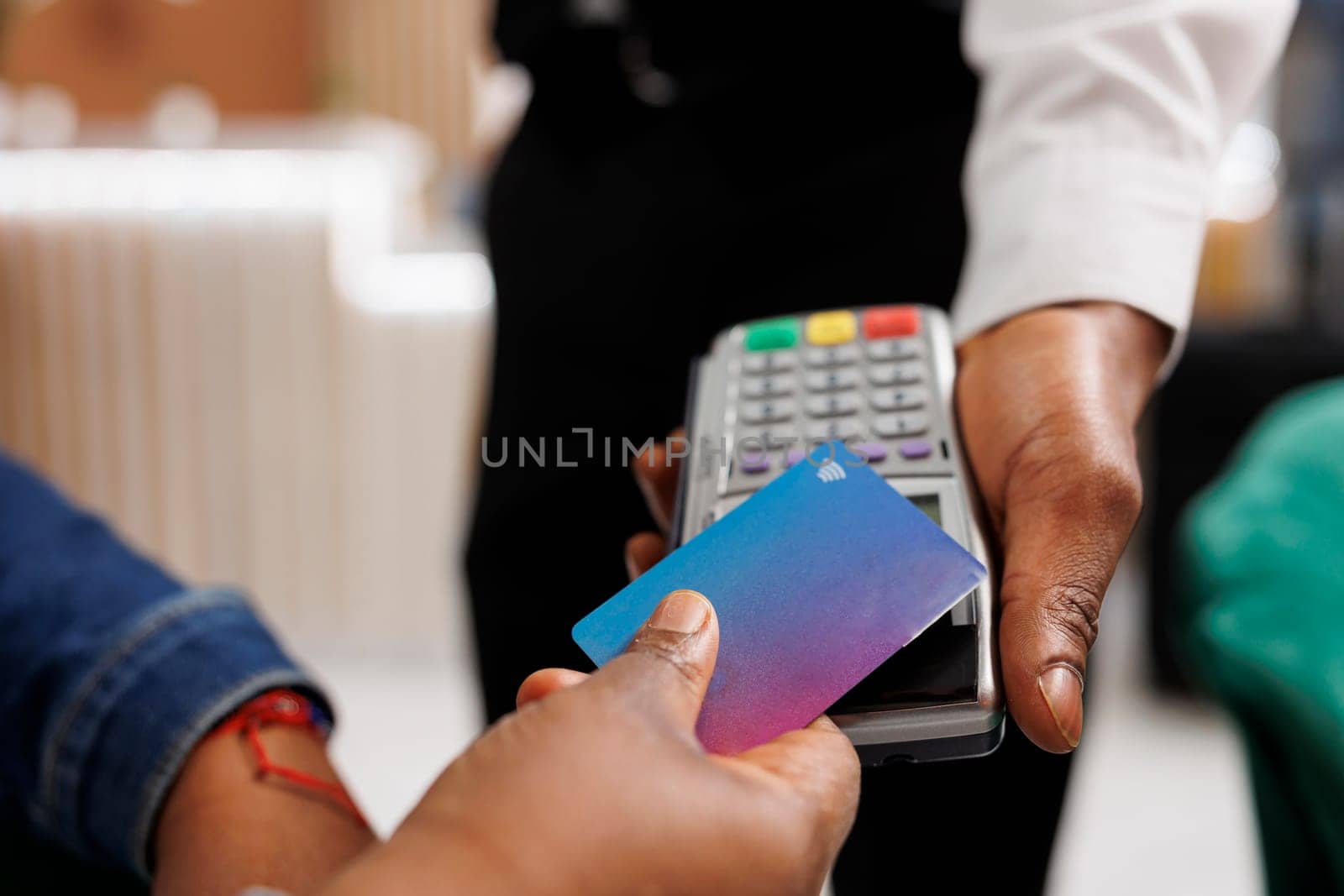 Customer hand making NFC transaction by DCStudio