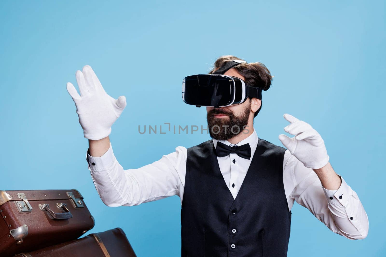 Classy bellboy using virtual reality on headset, symbolizing modern hospitality industry in studio. Hotel porter wearing white gloves and vr glasses, providing luxury services.