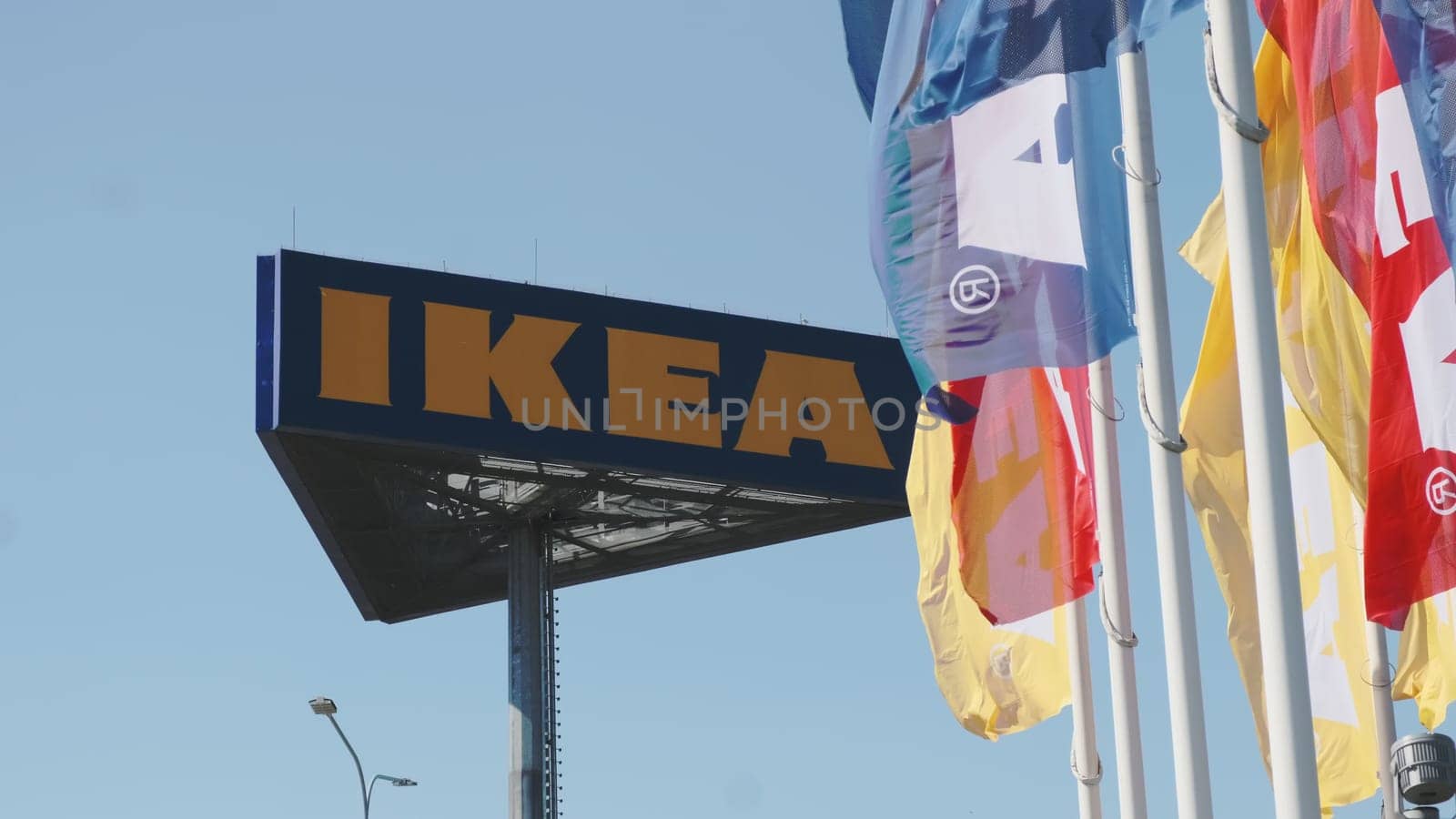 PRAGUE, CZECHIA -APRIL, 2024: IKEA flags waving in the wind against sky and signboard.
