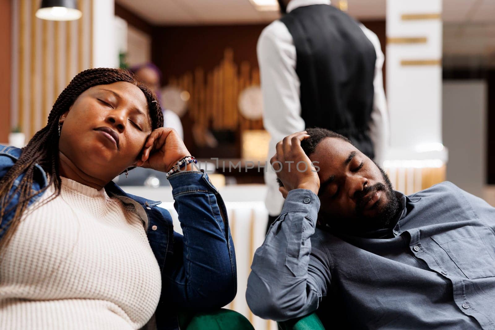 Tired couple napping in hotel lobby by DCStudio