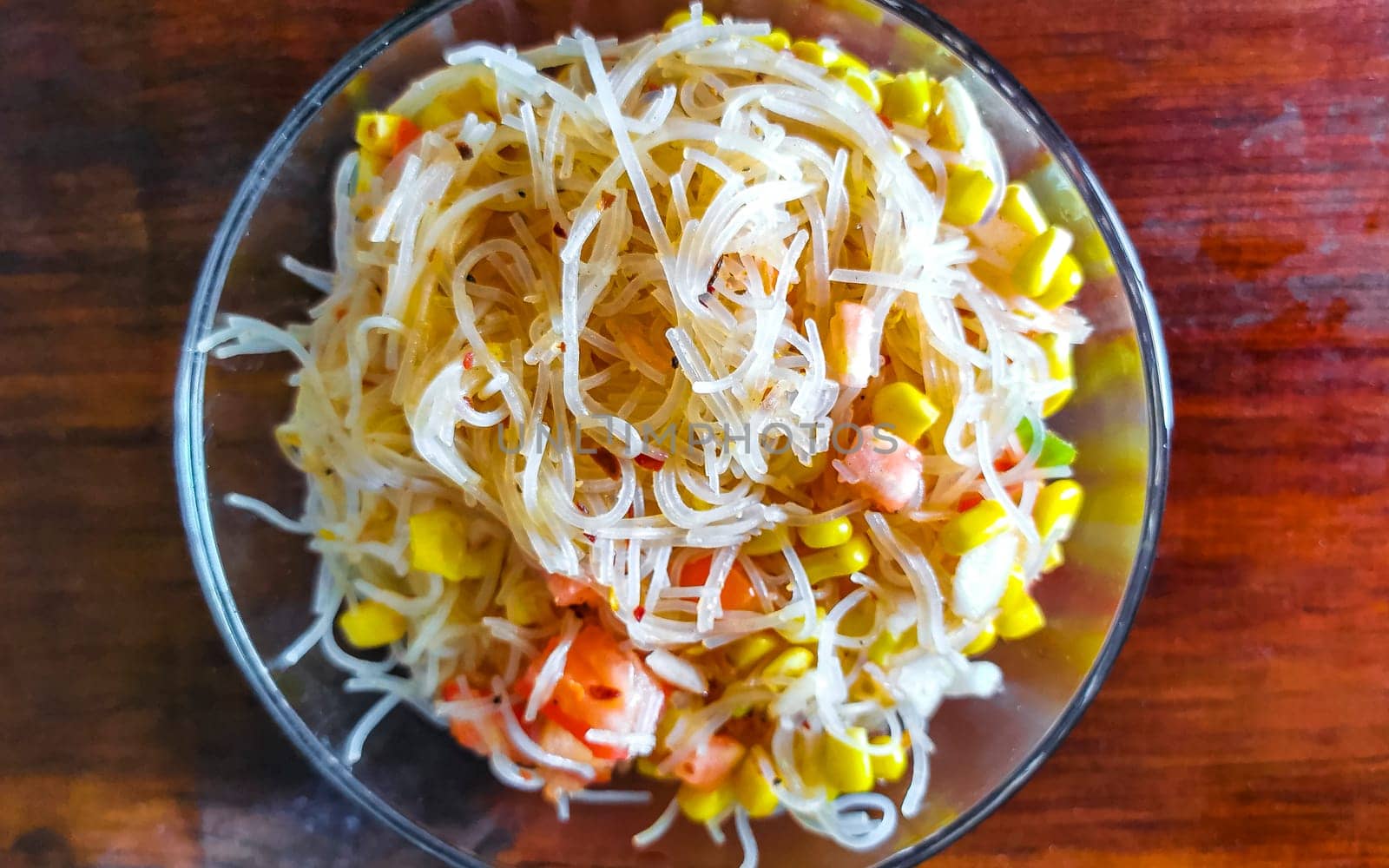 Dish of glass noodles with corn onions and tomatoes in Zicatela Puerto Escondido Oaxaca Mexico.