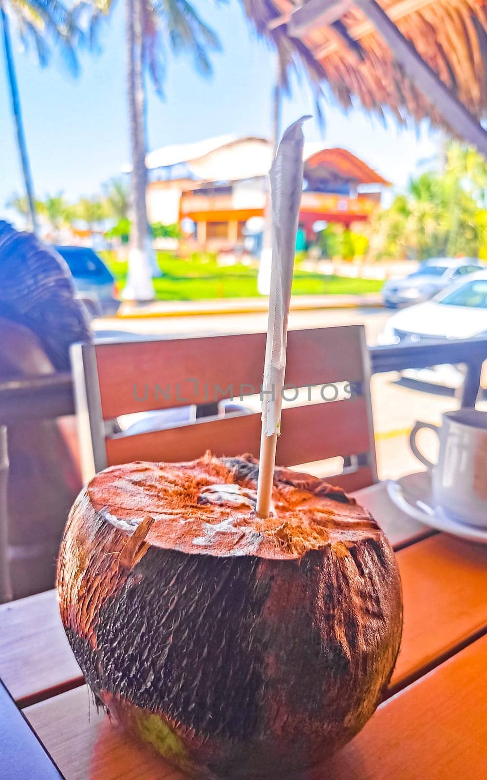 Tropical coconut with straw on the table in Zicatela Puerto Escondido Oaxaca Mexico.