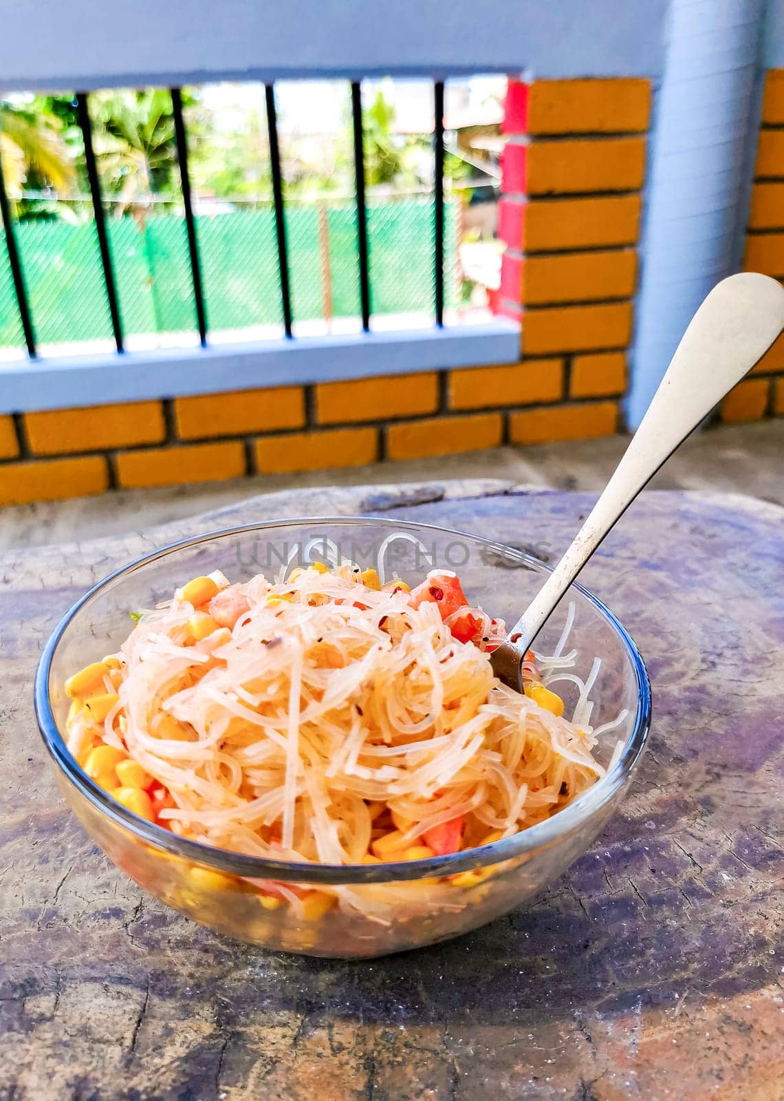 Dish of glass noodles with corn onions and tomatoes in Zicatela Puerto Escondido Oaxaca Mexico.