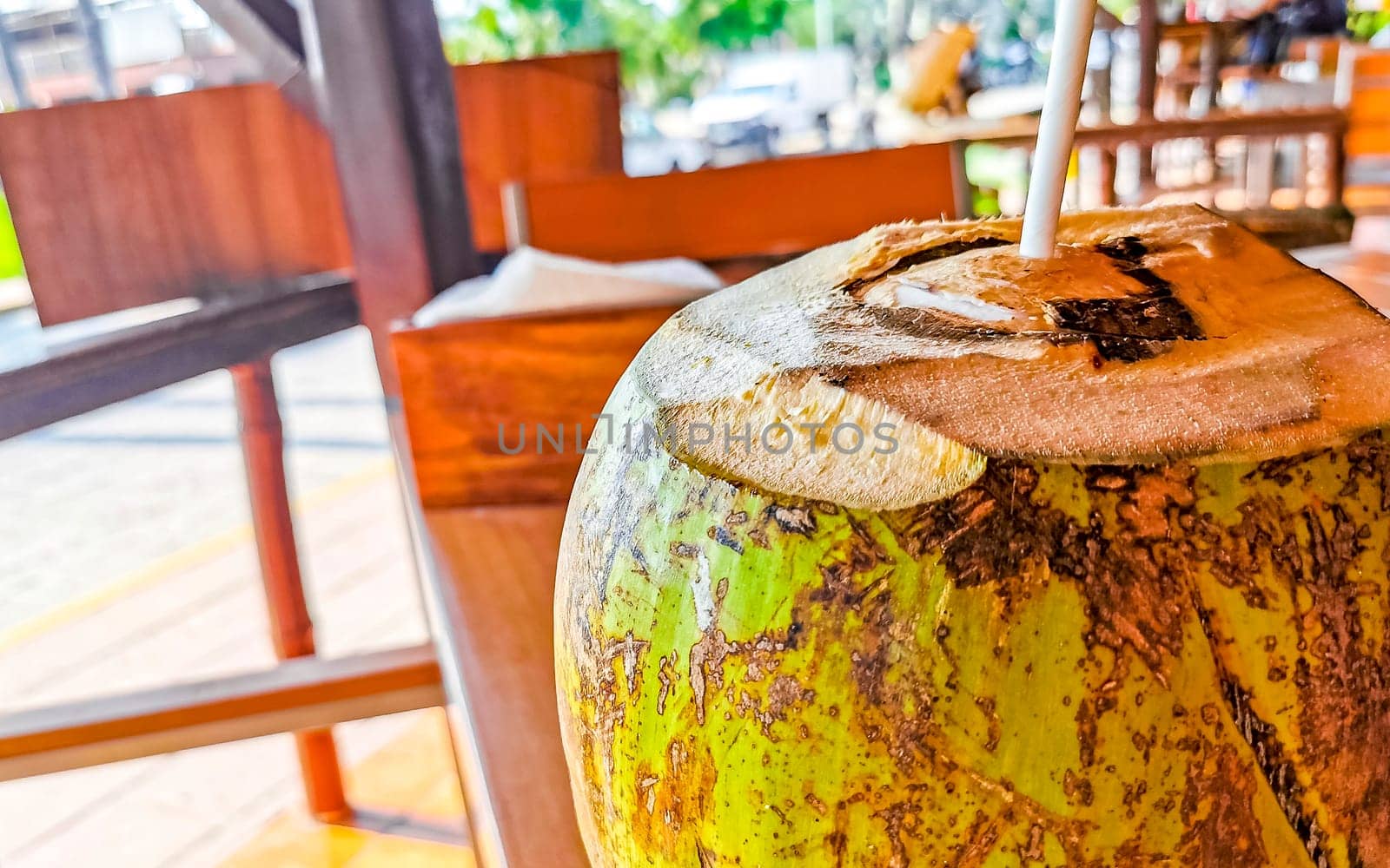 Tropical coconut with straw on the table in Zicatela Puerto Escondido Oaxaca Mexico.
