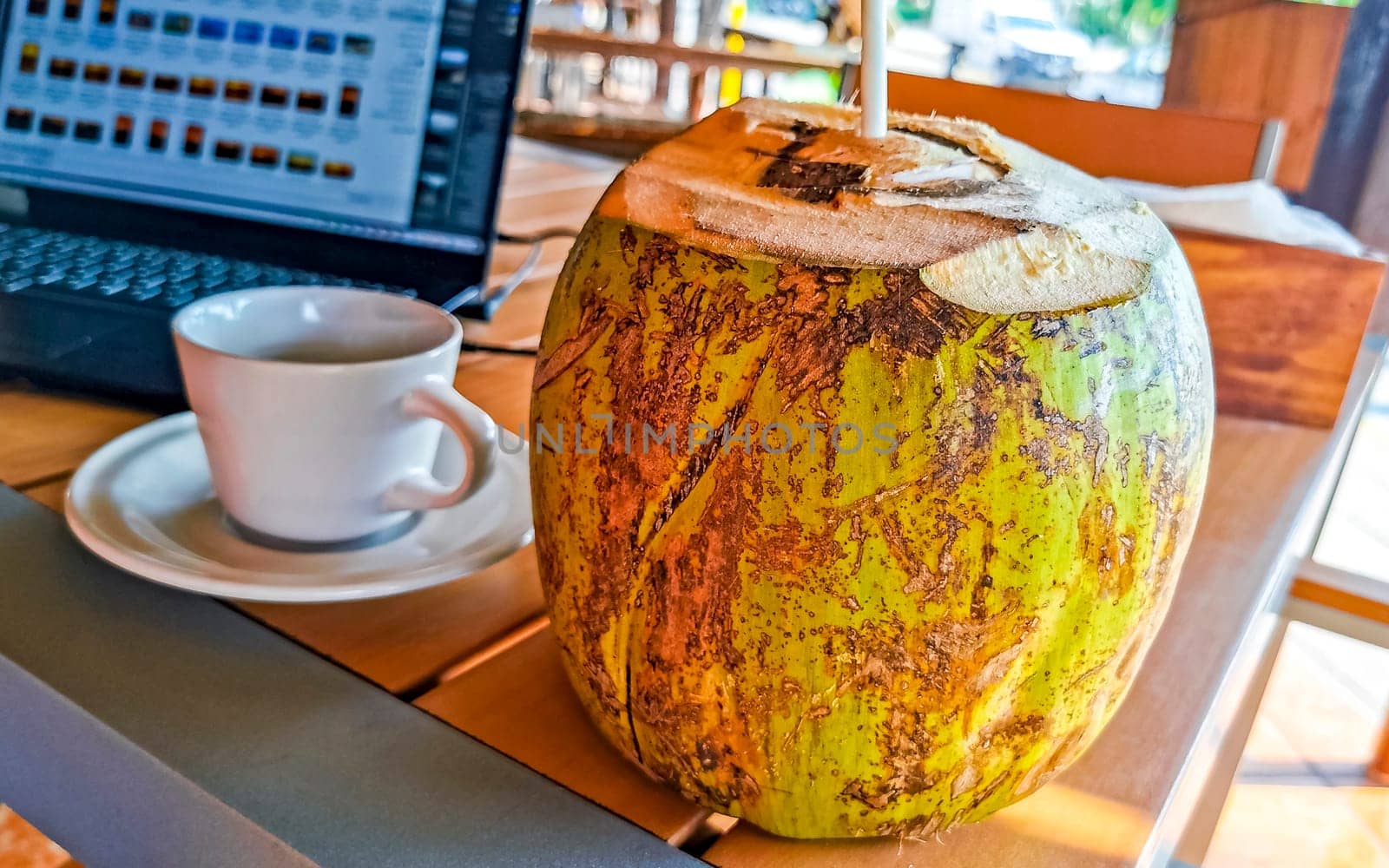 Tropical coconut with straw on the table Puerto Escondido Mexico. by Arkadij