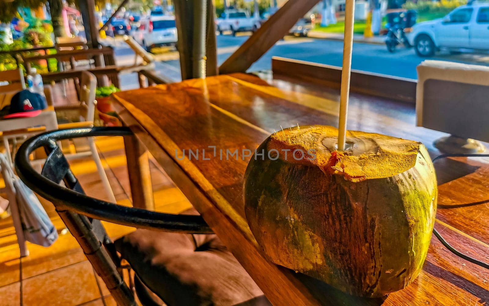 Tropical coconut with straw on the table in Zicatela Puerto Escondido Oaxaca Mexico.