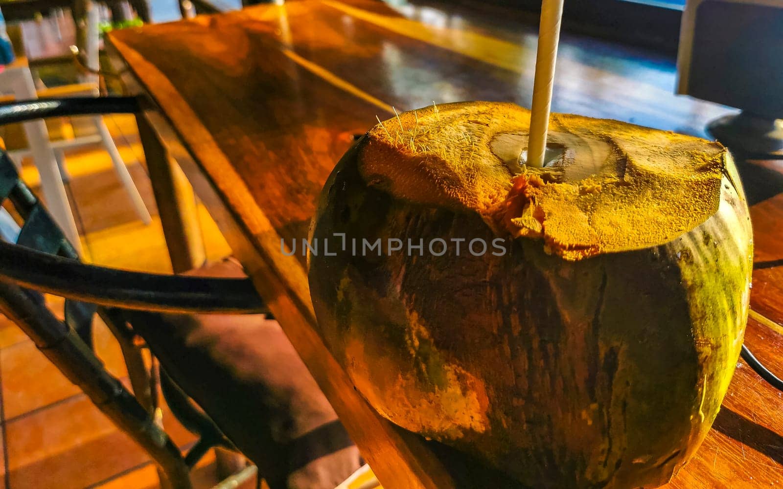 Tropical coconut with straw on the table Puerto Escondido Mexico. by Arkadij