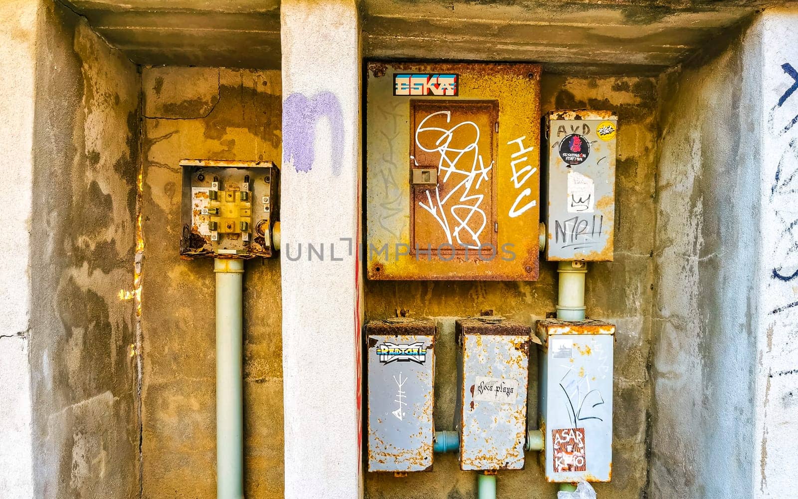 Old broken electricity meters on the wall in Mexico. by Arkadij