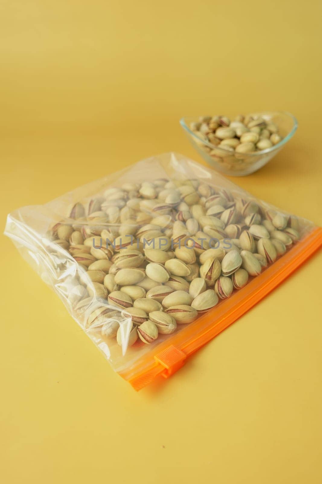 pistachios nuts in a plastic bag on color background ,