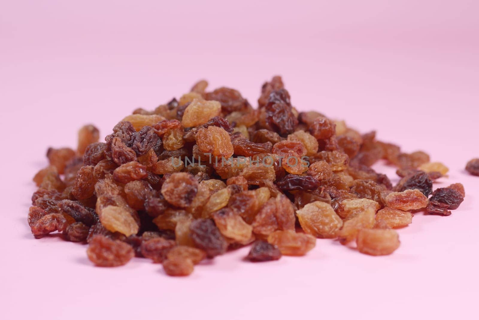 brown raisin on pink background, close up, by towfiq007