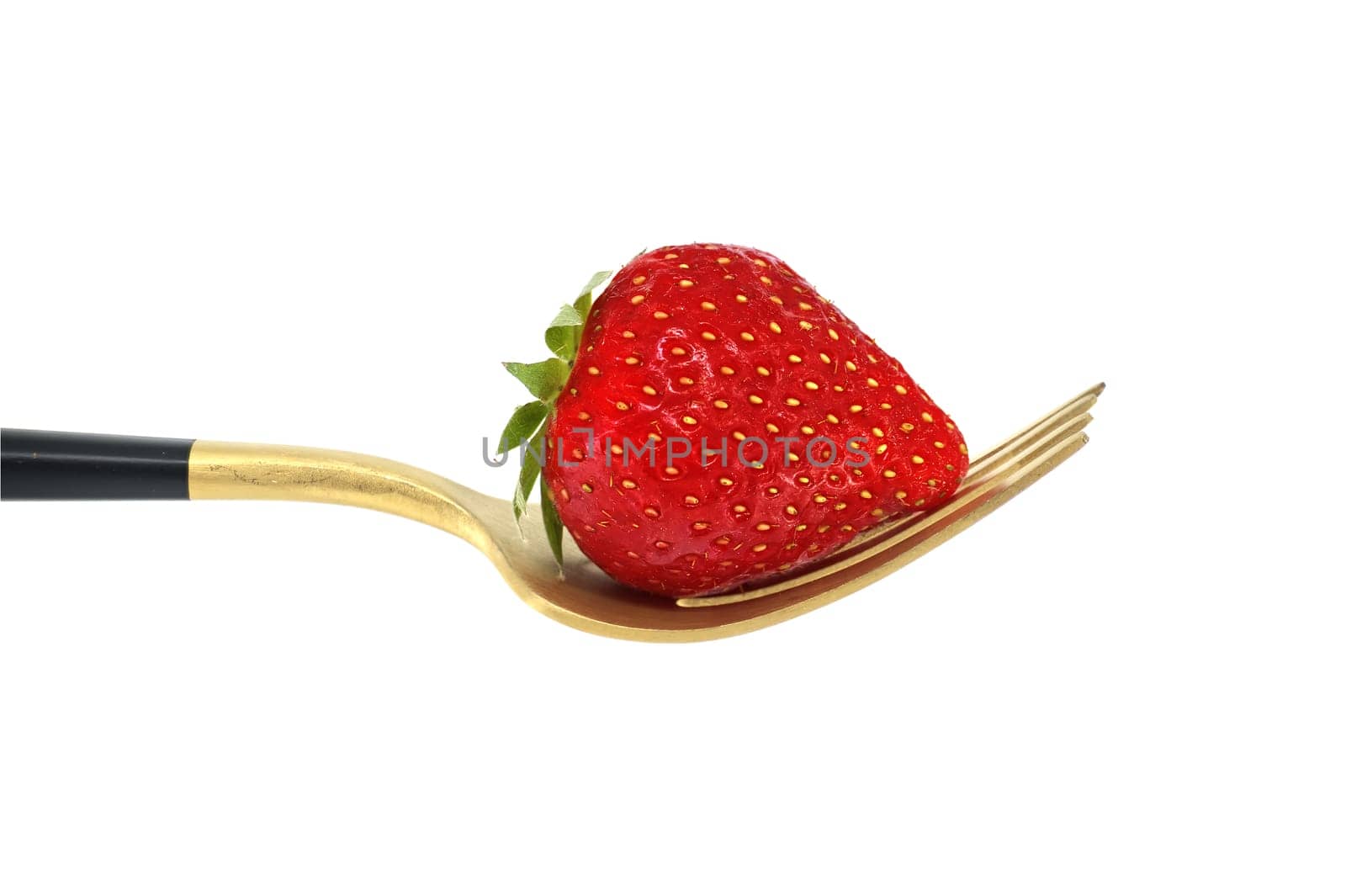 Red strawberry arranged on gold fork with a black handle, set against a white background, symbolizing a concept of healthy diet and organic food