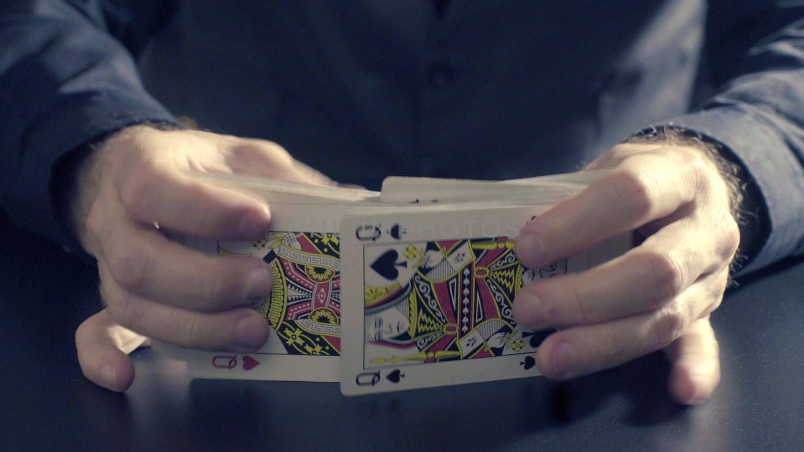 Poker game - shuffling cards. Man's hands shuffing cards. Close up