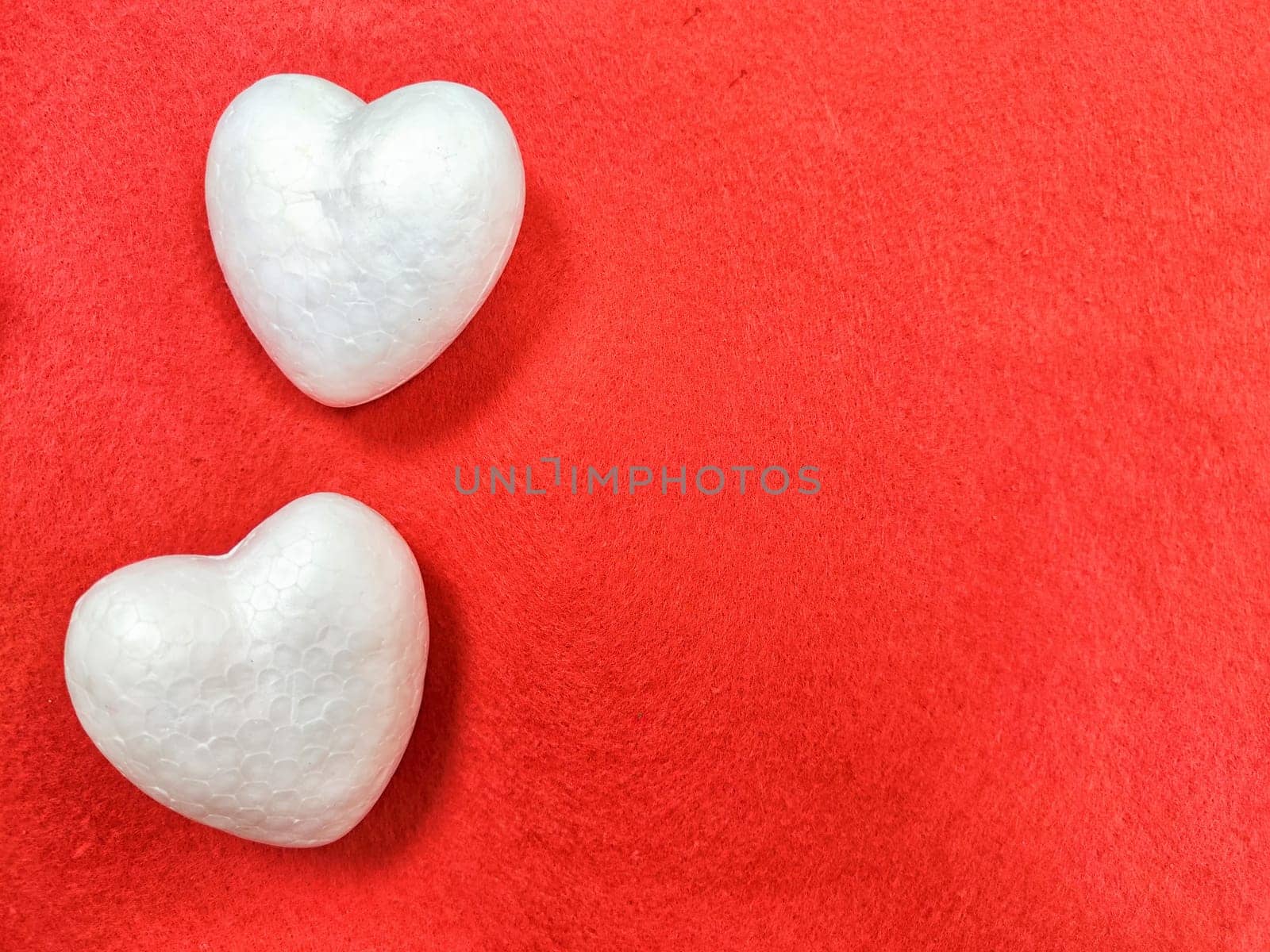 White foam hearts on a red background. The texture. valentine's day. Two White Foam Hearts on a Textured Red Background for Valentines Day by keleny